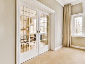 a living room with doors leading to a dining room